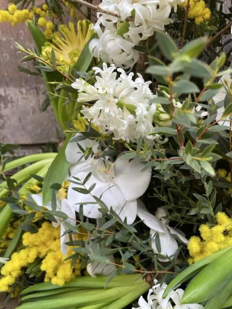 detail fleurs blanches mimosa devant de tombe composition de deuil artisan fleuriste Paris 11 proche Pere Lachaise Paris 20