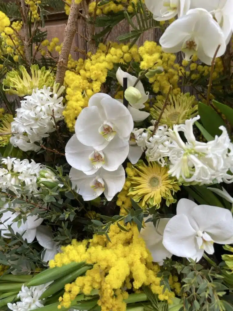 Détails devant de tombe mimosa jaune orchidées blanches fleurs de deuil artisan fleuriste Paris 11 proche Père Lachaise Paris 20