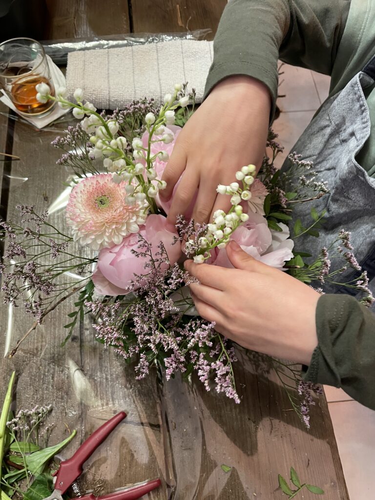 Création florale printanière avec pivoines roses, muguet et fleurs légères réalisée lors d’un atelier chez Yann-H2o artisan fleuriste à Paris 11