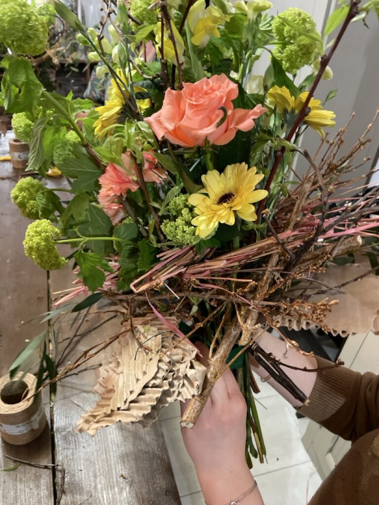 Bouquet contemporain composé de fleurs de saison, branches naturelles et matières végétales créé lors d’un atelier floral chez Yann-H2o à Paris 11