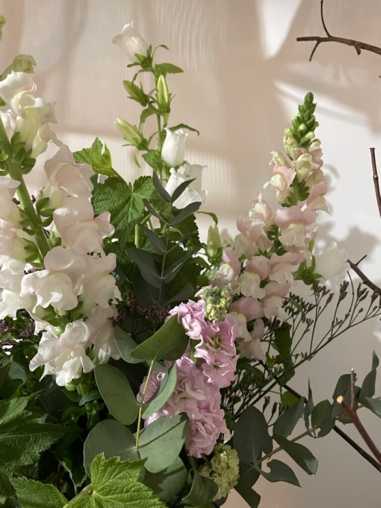 Bouquet romantique composé de mufliers roses pastel, campanules blanches et feuillages d’eucalyptus dans un style naturel et raffiné créé à Paris 11