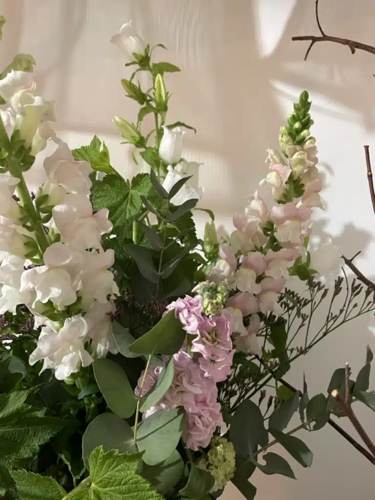 Bouquet romantique composé de mufliers roses pastel, campanules blanches et feuillages d’eucalyptus dans un style naturel et raffiné créé à Paris 11