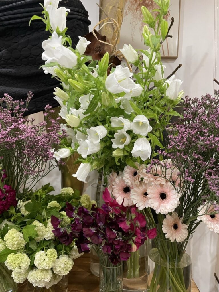 Grandes campanules blanches entourées de fleurs de saison dans une ambiance d’atelier floral créatif à Paris 11
