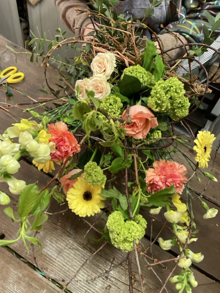 Composition florale naturelle et aérienne réalisée avec fleurs de saison, viburnums, roses et branches graphiques dans l’atelier Yann-H2o à Paris 11