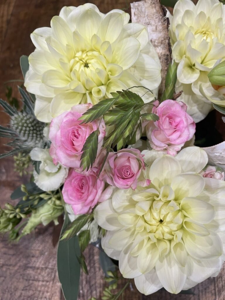 Bouquet de fleurs de saison réunissant des dahlias blancs, des roses roses, une orchidée Phalaenopsis et des feuillages, réalisé par Yann-H2o, artisan fleuriste à Paris 11.