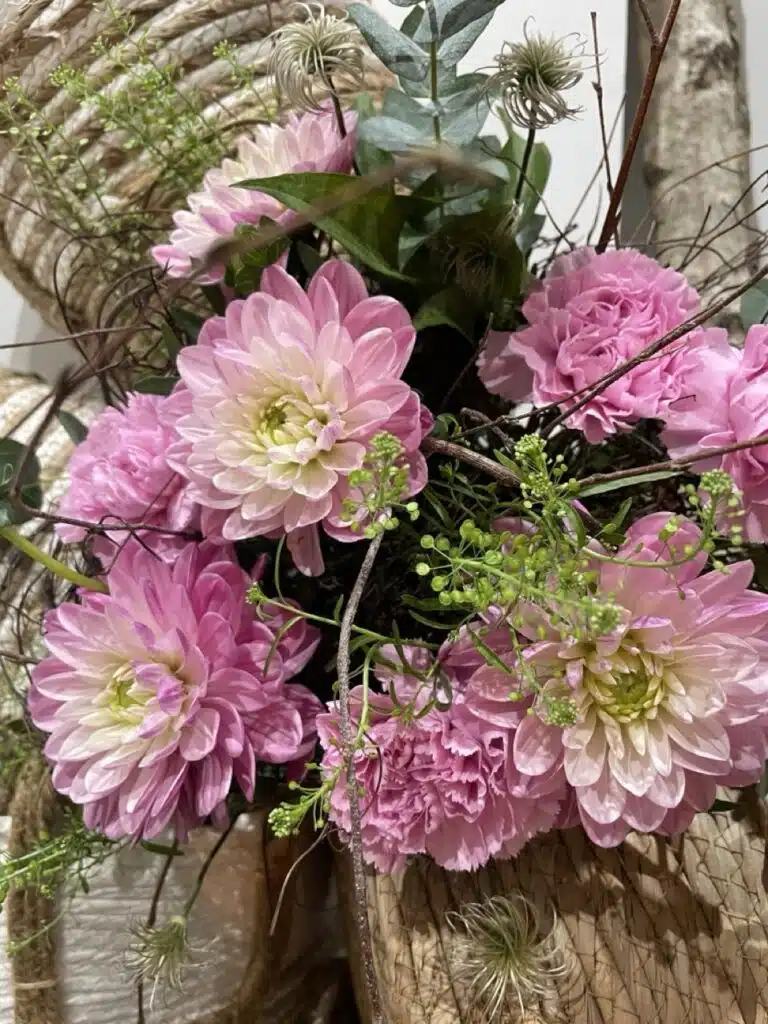 Composition florale réalisée avec des dahlias roses de saison, des œillets et des feuillages, créée par Yann-H2o, artisan fleuriste à Paris 11.