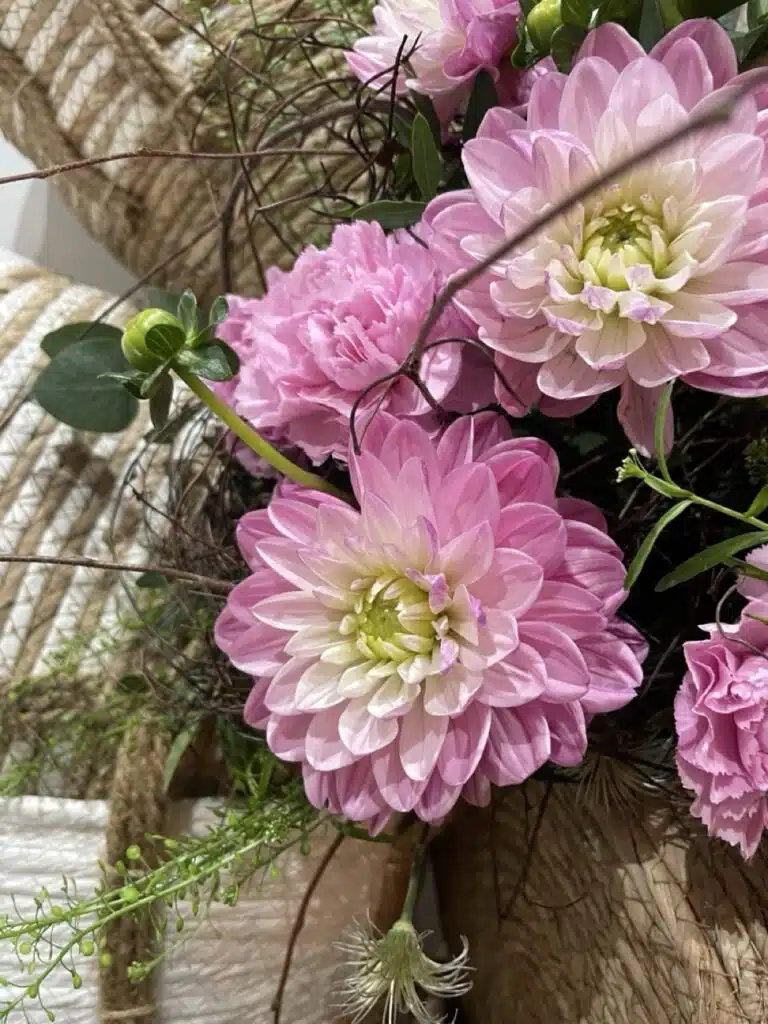 Composition florale réalisée avec des dahlias roses, des œillets et des feuillages de saison par Yann-H2o, artisan fleuriste à Paris 11, pour des bouquets élégants et naturels.
