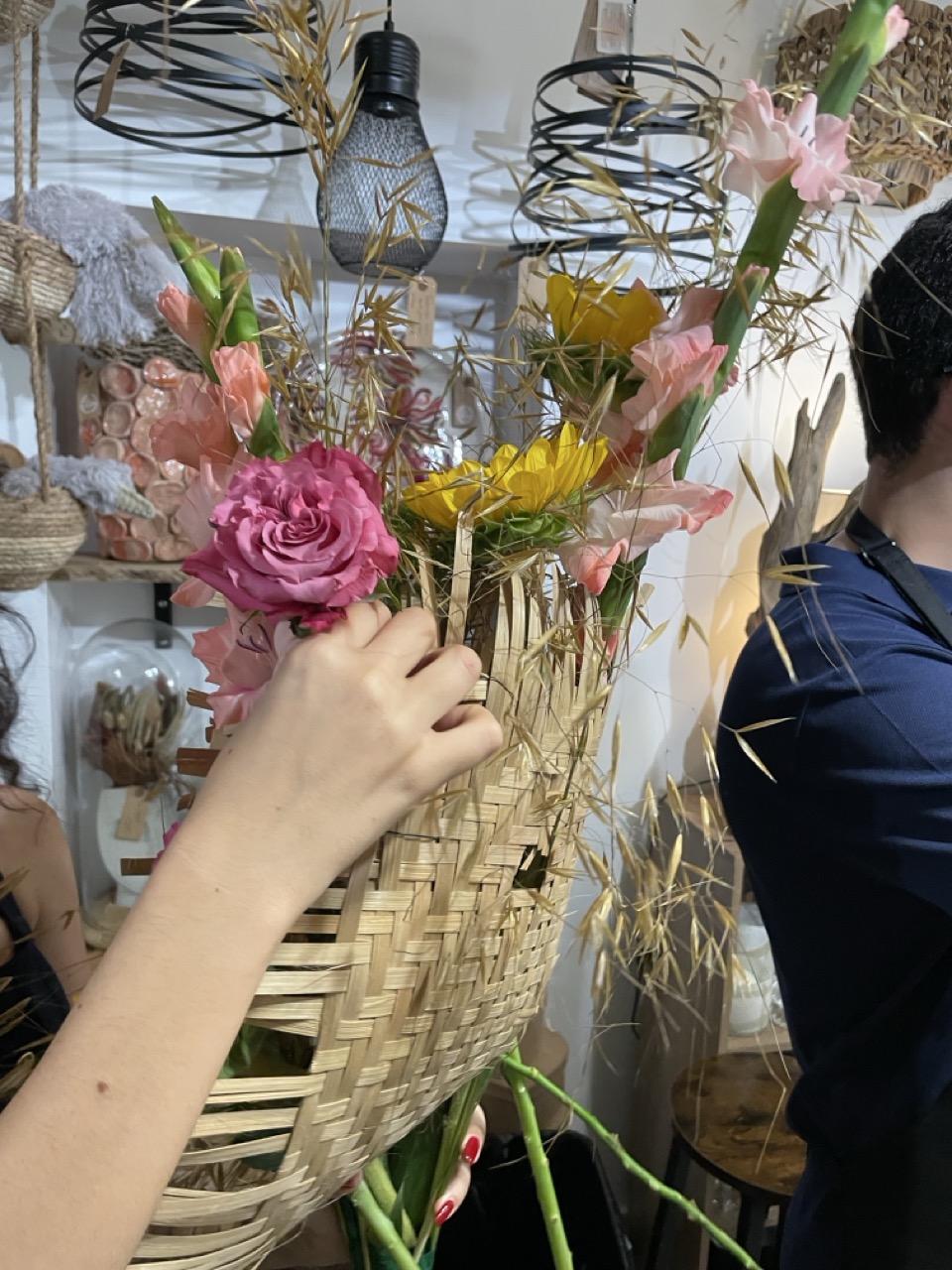 Participant réalisant une création florale avec des fleurs de saison dans un contenant tressé lors d'un atelier convivial animé par Yann-H2o, artisan fleuriste créateur à Paris 11. Chaque atelier est un moment de partage où créativité, savoir-faire artisanal et bonne humeur s'expriment autour du végétal.