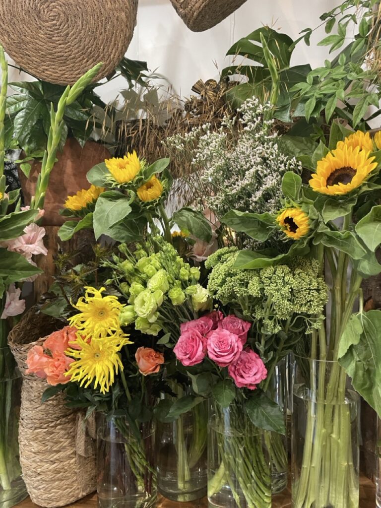 Tournesols, roses et fleurs de saison fraîchement sélectionnés dans la boutique d'un artisan fleuriste rue Pache à Paris 11. Bouquets personnalisés et livraison de fleurs dans tout Paris.