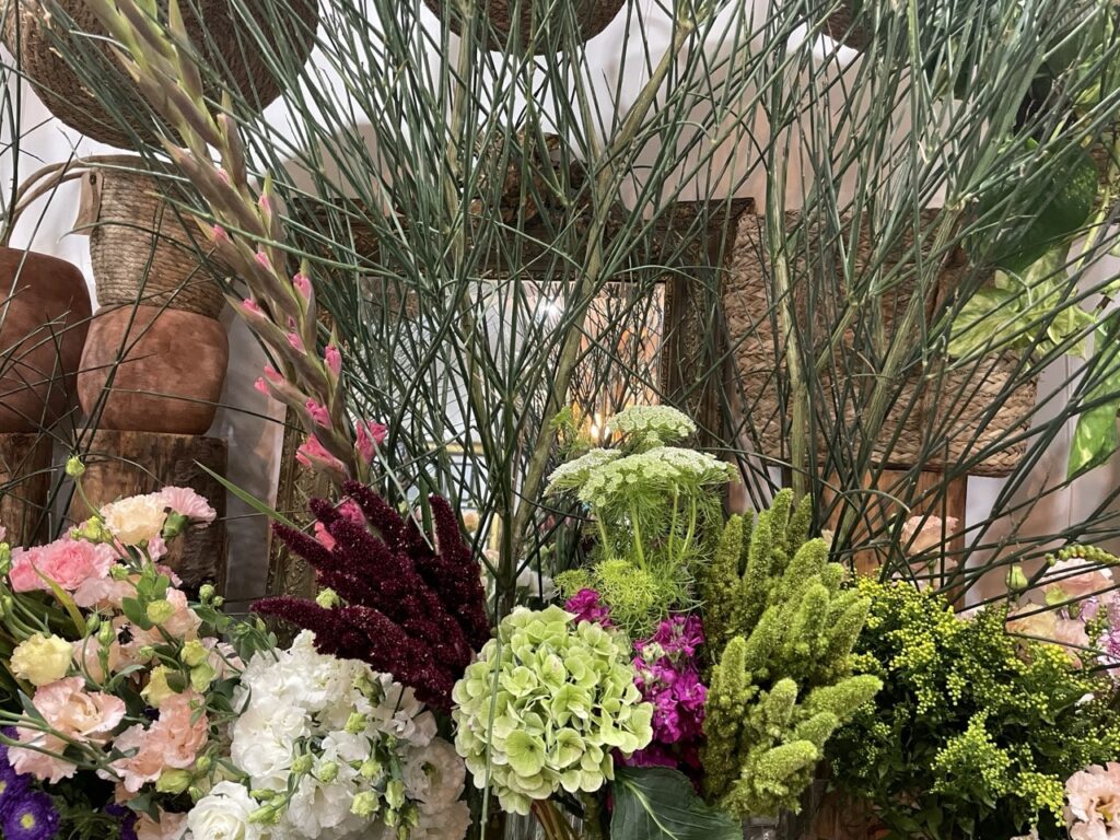 Amarantes vertes et pourpres entourées d’hortensias, de fleurs roses et de feuillages dans la boutique Yann-H2o, artisan fleuriste à Paris 11.